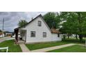 Side view of a charming house featuring white siding, brown trim, and well-maintained landscaping at 35 Meadow Dr, New Palestine, IN 46163