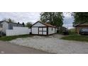 Detached outbuilding with white siding and brown trim, offering extra storage or workspace at 35 Meadow Dr, New Palestine, IN 46163