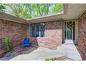 Exterior entrance boasts brick facade, blue chair and decorative window at 4080 S London Dr, Martinsville, IN 46151
