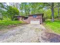 Charming brick home featuring an attached garage and surrounded by mature trees at 4080 S London Dr, Martinsville, IN 46151