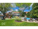 Spacious backyard with a pool, lounge chairs, and mature trees, perfect for outdoor entertaining and relaxation at 4619 Allen Dr, Carmel, IN 46033