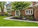 Inviting front entrance with a curved walkway, decorative landscaping, and a well-maintained brick facade at 4619 Allen Dr, Carmel, IN 46033