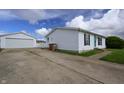 Property featuring a long driveway, detached garage, and a well-maintained one-story home at 4632 Willowbrook Dr, Columbus, IN 47203