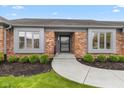 Inviting entryway featuring a curved walkway, brick facade, and well-maintained landscaping at 4711 Bentley Dr, Carmel, IN 46033