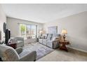 Cozy living room with neutral tones, large window, and comfortable seating arrangement at 4711 Bentley Dr, Carmel, IN 46033