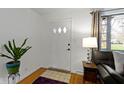 Cozy entryway with hardwood floors, a side table and view to a charming front porch at 5005 Bonnie Brae St, Indianapolis, IN 46228