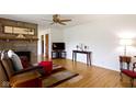 Spacious living room with a stone fireplace, ceiling fan and hardwood floors at 5005 Bonnie Brae St, Indianapolis, IN 46228