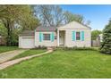 Charming single-story home featuring a manicured lawn, light siding, and bright blue shutters at 5254 Kingsley Dr, Indianapolis, IN 46220