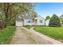 Charming single-story home featuring a manicured lawn, light siding, and bright blue shutters at 5254 Kingsley Dr, Indianapolis, IN 46220
