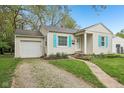 Charming single-story home featuring a manicured lawn, light siding, and bright blue shutters at 5254 Kingsley Dr, Indianapolis, IN 46220