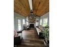 Cozy sunroom with a stone fireplace, wooden ceiling, and ample natural light at 5817 Jamestown Square Ln, Indianapolis, IN 46234