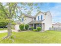 Traditional two-story home featuring tidy front yard landscaping, a two-car garage, and welcoming curb appeal at 5849 Wooden Branch Dr, Indianapolis, IN 46221