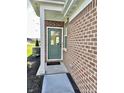Close up of front door with brick exterior, storm door, and welcome mat at 6040 Bluecrest Dr, Brownsburg, IN 46234