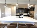 Features a modern kitchen island with quartz countertop, a stainless fridge, and stylish pendant lighting at 6040 Bluecrest Dr, Brownsburg, IN 46234