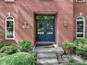 Close-up of brick home's entryway showcasing double doors with glass panels and decorative sconces at 7626 Timber Springs S Dr, Fishers, IN 46038