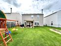 Spacious backyard with a lush lawn, wooden playset, and a covered outdoor seating area at 7804 Amadeus Dr, Indianapolis, IN 46239