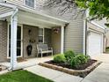 Inviting front porch with stylish seating, lush greenery, and a decorative hanging flower basket at 7804 Amadeus Dr, Indianapolis, IN 46239