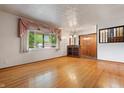 Bright living room featuring hardwood floors and a large window with decorative curtains at 8140 Valley Estates Dr, Indianapolis, IN 46227