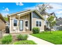 Inviting front exterior showcasing a quaint covered porch and manicured lawn under a bright blue sky at 829 Olive St, Indianapolis, IN 46203