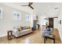Bright living room with hardwood floors, neutral tones, and open layout to kitchen and dining area at 829 Olive St, Indianapolis, IN 46203
