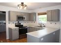 Kitchen features gray cabinets, stainless steel appliances, updated counter tops, and a window over the sink at 8551 Walden Trace Dr, Indianapolis, IN 46278