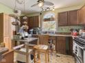 Dated kitchen featuring wood cabinets, a window above the sink, and hanging storage baskets at 907 S Ohio St, Sheridan, IN 46069