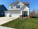 Charming two-story home with a three-car garage, landscaping, and well-manicured lawn at 9074 Larson Dr, Pendleton, IN 46064