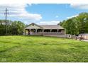 Single-story home with a covered front porch overlooking a large grassy yard with mature trees at 9510 N Cooney Rd, Mooresville, IN 46158