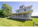 Charming two-story home featuring a wrap-around porch, well maintained lawn, and mature trees at 9579 N Fortville Pike, Fortville, IN 46040