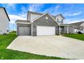 Spacious two-story home with black brick, gray siding, concrete driveway, attached two-car garage, and well-kept front lawn at 10236 Arctic Edge Dr, Indianapolis, IN 46239