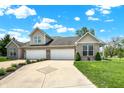 Inviting home with a long driveway, two-car garage, and lush green lawn and mature trees at 1118 Kristi Ct, Greenwood, IN 46142