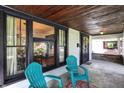 Inviting covered porch with seating, wood ceiling and decorative door with natural lighting at 1124 E 35Th St, Indianapolis, IN 46205
