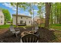 Landscaped backyard featuring mature trees, fire pit area, and play structure at 11243 Catalina Dr, Fishers, IN 46038