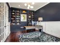 Stylish home office with custom built-ins, modern desk, and beautiful hardwood floors at 11323 Still Creek Dr, Zionsville, IN 46077