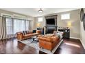 Cozy living room with leather sofas, fireplace, and large windows for abundant natural light at 11323 Still Creek Dr, Zionsville, IN 46077