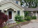 Side entry features a well-lit covered space, complemented by mature landscaping and a brick driveway at 1138 E 58Th St, Indianapolis, IN 46220