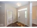 Warm foyer featuring hardwood floors, a white front door with sidelights, and a glass-paneled door at 11473 Rainbow Falls Ln, Fishers, IN 46037