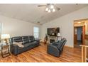 Comfortable living room with hardwood floors, black leather furniture, fireplace, and ceiling fan at 1157 Fielding Ln, Franklin, IN 46131
