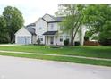 Inviting two-story home with a lush green lawn and mature shade tree at 12115 Flagstone Dr, Fishers, IN 46037