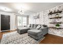 Comfortable living room featuring a brick accent wall, a large sofa, and stylish decor at 1242 Freemont Ln, Greenwood, IN 46143