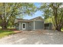 Back of home shows gravel driveway and green grass, as well as a storage shed at 129 Rosewood Dr, Cicero, IN 46034