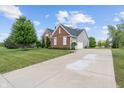 Wide concrete driveway leading to a two-car garage, surrounded by well-kept lawn at 13553 Lorenzo Blvd, Carmel, IN 46074