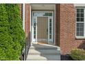 Inviting front entrance with sidelights, showcasing brick facade and landscaped greenery at 13553 Lorenzo Blvd, Carmel, IN 46074