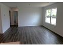 Bright living room with dark wood flooring and a large window at 1400 Bluebonnet Pl, Shelbyville, IN 46176