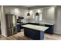 Modern kitchen with stainless steel appliances, white and navy cabinets, and a center island with marble countertop at 1536 Copperwood Pl, Carmel, IN 46033