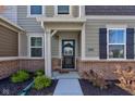 Inviting entryway with wreath-adorned door and stylish brick accents around the front porch at 17237 Rancorn Pl, Westfield, IN 46074