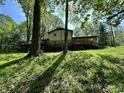 Exterior view of the home showcasing the deck and the surrounding yard at 1760 Pumpkinvine Hill Rd, Martinsville, IN 46151
