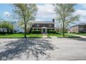 Lovely brick home with green lawn, blue shutters and door, flanked by mature trees at 1787 Halifax St, Carmel, IN 46032