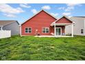 Exterior shot of a home's backyard, featuring a cozy covered patio area and a spacious green lawn at 2006 Monticlair Ln, Columbus, IN 47201