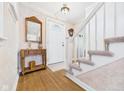 Foyer with wood floors, stairs, vintage lamp, mirror, and a front door at 2011 Sheffield Ave, Anderson, IN 46011
